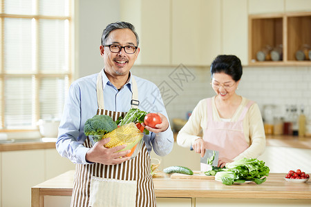 厨房里中老年男士手捧新鲜蔬菜图片