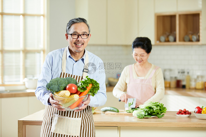 厨房里中老年男士手捧新鲜蔬菜图片