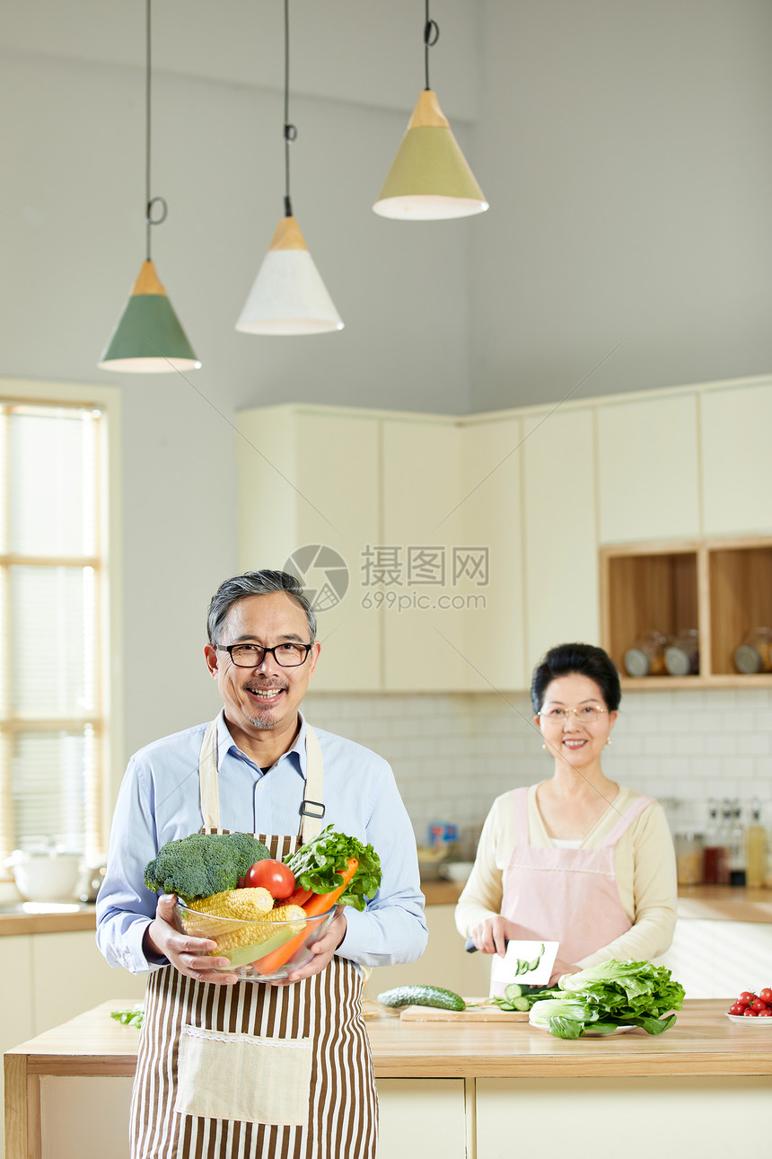 厨房里中老年男士手捧新鲜蔬菜图片