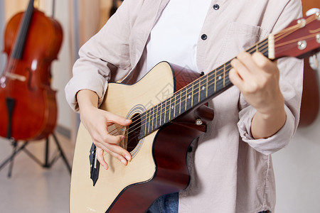 练习吉他的女性弹吉他的人背景图片
