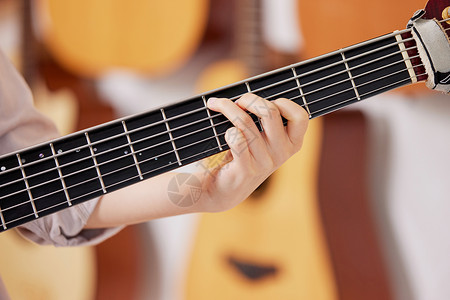 弹吉他吉他的女性按和弦的手背景图片
