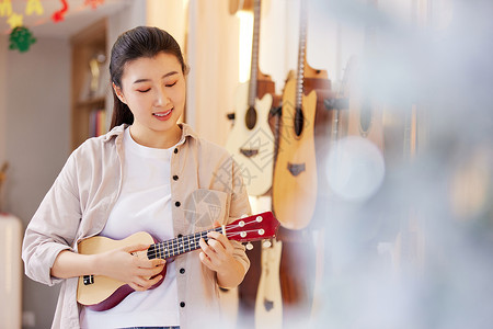 秋季乐器培训班弹奏尤克里里的女性背景