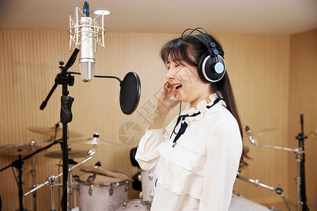 眼睛耳机素材女性在录音棚闭着眼睛唱歌背景
