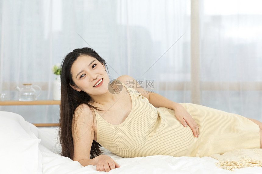 侧躺在床上的孕妇形象图片