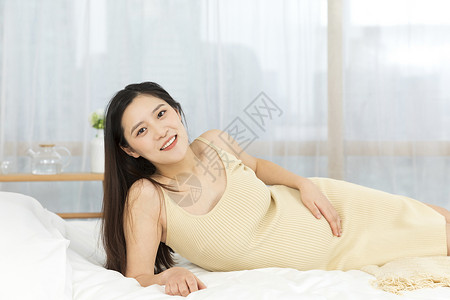侧躺在床上的孕妇形象图片
