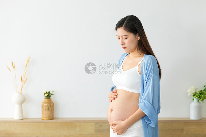 低头扶着肚子的孕妇图片