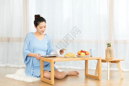 居家休息的孕妇看书图片