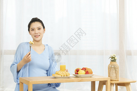 居家休息的孕妇吃着水果图片