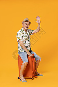 夏威夷衫坐在行李箱上的老人旅行背景