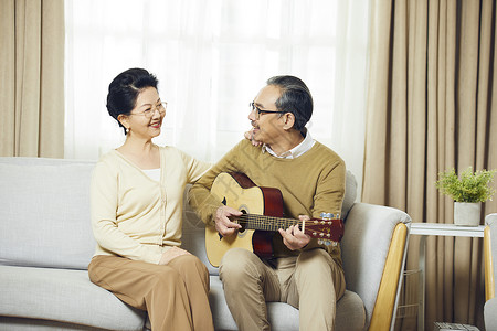 中老年夫妇在客厅弹吉他对视图片