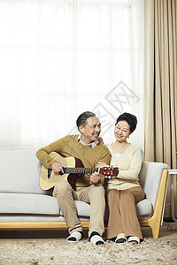 中老年夫妇在客厅相伴弹吉他图片