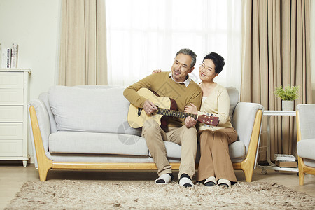 坐着弹吉他中老年夫妇在客厅弹吉他背景