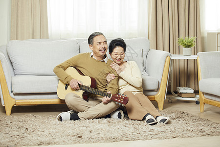 中老年夫妇在客厅相伴弹吉他图片