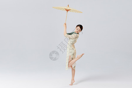 旗袍美女舞者拿油纸伞跳舞图片