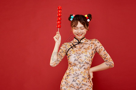 中国风传统旗袍美女拿冰糖葫芦图片