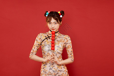 中国风传统旗袍美女拿冰糖葫芦图片