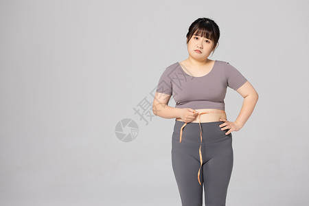 卷尺使用女性使用卷尺测量腰围背景