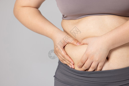 体脂仪捂着肚子的肥胖女性背景