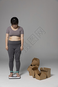 女性歧视站在外卖盒旁称体重的女性背景