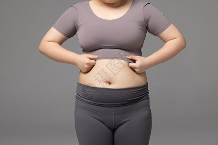 肚子肉不开心的肥胖女性看着肚子上的肉背景
