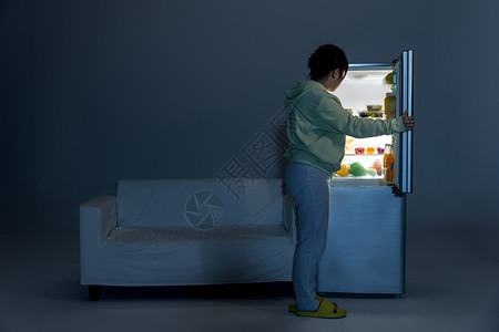 晚上打开冰箱偷吃的女性背景图片