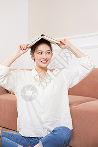 头顶书本的女青年学生形象背景图片