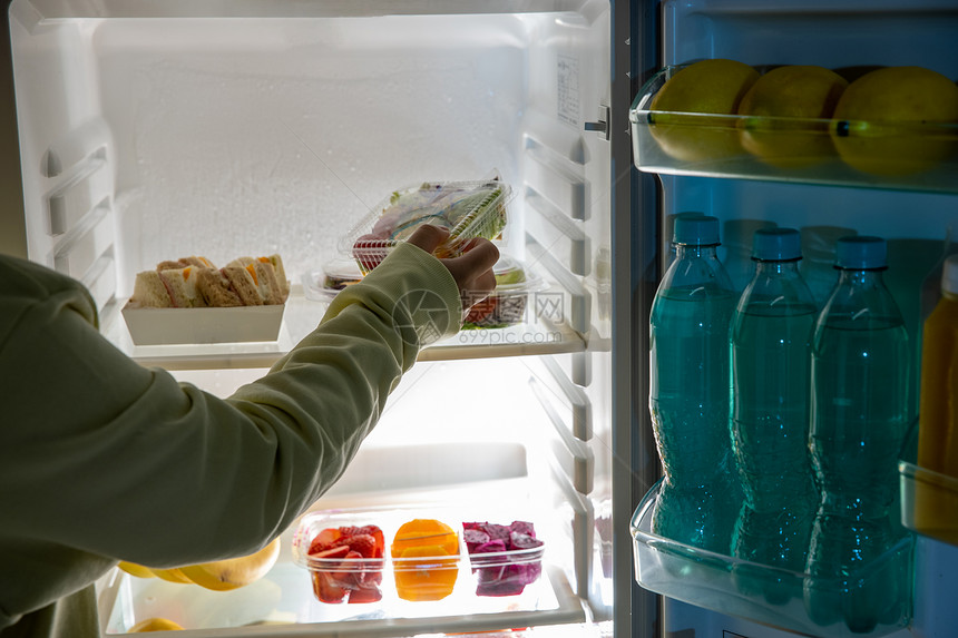 从冰箱里拿出食物的手图片