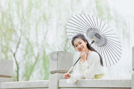 中国风少女古风汉服少女公园里撑伞背景