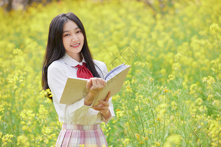 校园春天油菜花花海中的少女看书背景