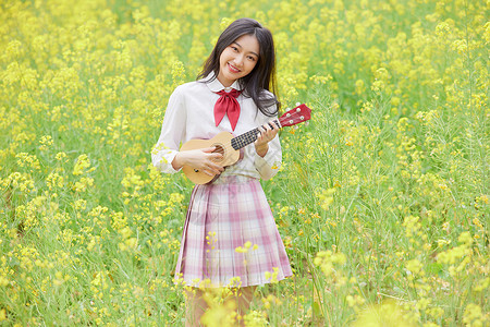 jk油菜花花海中的少女弹吉他背景