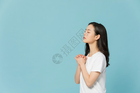 闭眼祈祷的女性图片