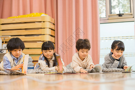 幼儿读书小朋友们趴在地上看书背景