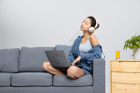 居家女性坐在沙发上听音乐背景