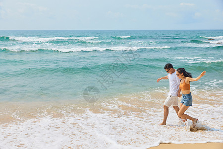 沙滩追逐年轻情侣海边旅行背景