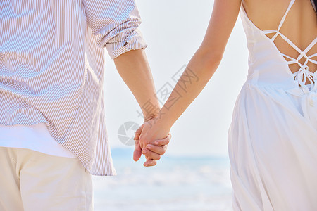 海边夫妻年轻情侣海边牵手特写背景