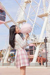 穿裙子拿气球的女孩青春可爱美少女拿棉花糖逛游乐园背景