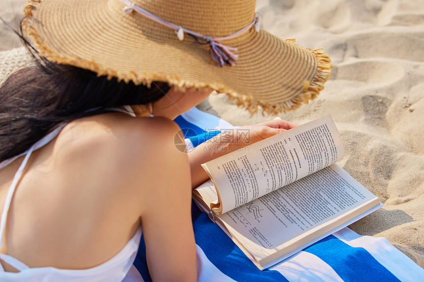年轻美女海边度假阅读图片