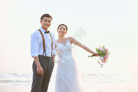 年轻情侣海边婚纱照背景图片
