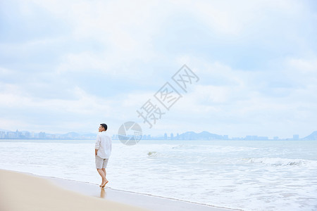 年轻男士夏天海边散步背影图片
