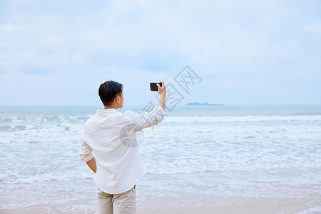 年轻男士海边散步背影图片