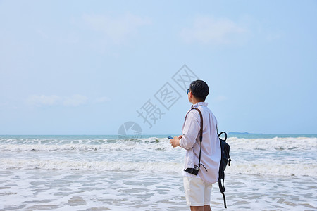 年轻男士海边旅游拍照图片