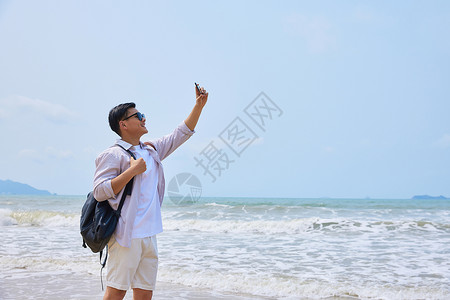 年轻男士海边旅游拍照图片