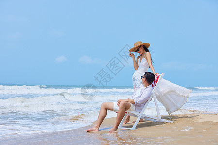 夏季沙滩椅年轻情侣海边开心度假背景