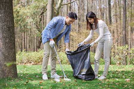 文明教育青年情侣志愿者公园里捡垃圾背景