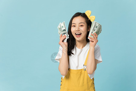 拿着钞票表情开心的年轻女性高清图片