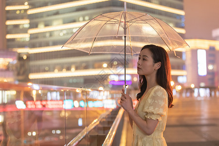 城市里撑着伞散步的女性图片