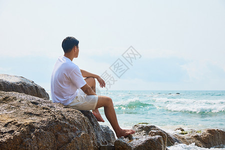 年轻男士面向大海思考背景图片