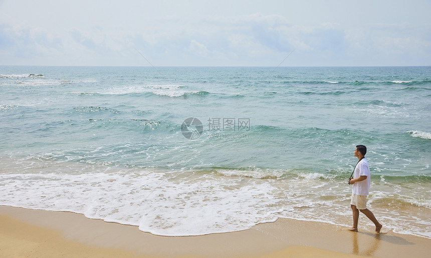 年轻男士拿着海边旅行图片