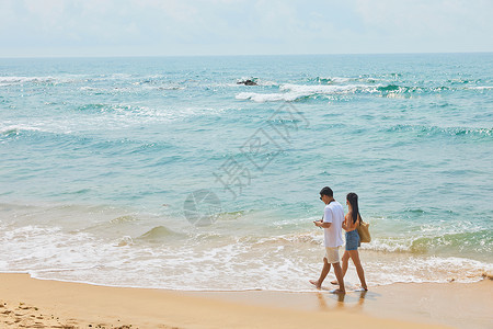 年轻情侣海边旅行背影图片