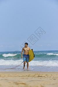 沙滩冲浪男孩年轻男士拿着冲浪板海边行走背景